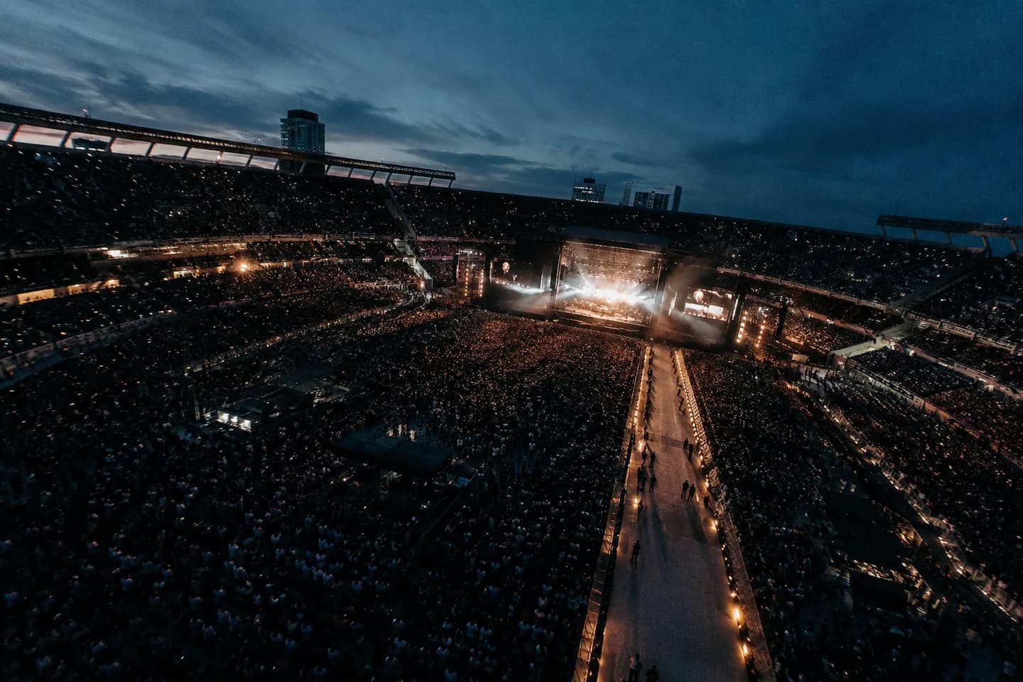 Vista aérea de un recital en un estadio al anochecer
